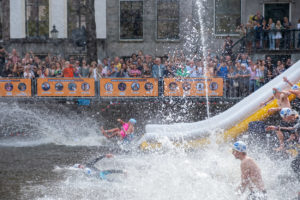 De eerste wave duikt het water in bij de Amsterdam City Swim.